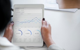 Digital health technology person holding tablet with graphs displayed on the screen