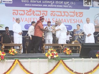 Dr.Veerendra Heggade, Head of Jain Center Dharmasthala in India honours Dr.Thomas Scaria, Director of Ecolink Institute The Governor of Karnataka handing over the Life Time Achievement award for SUD prevention and Management