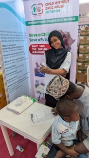 Parent filling our survey form during the  Pharmaceutical society of Nigeria conference 2025